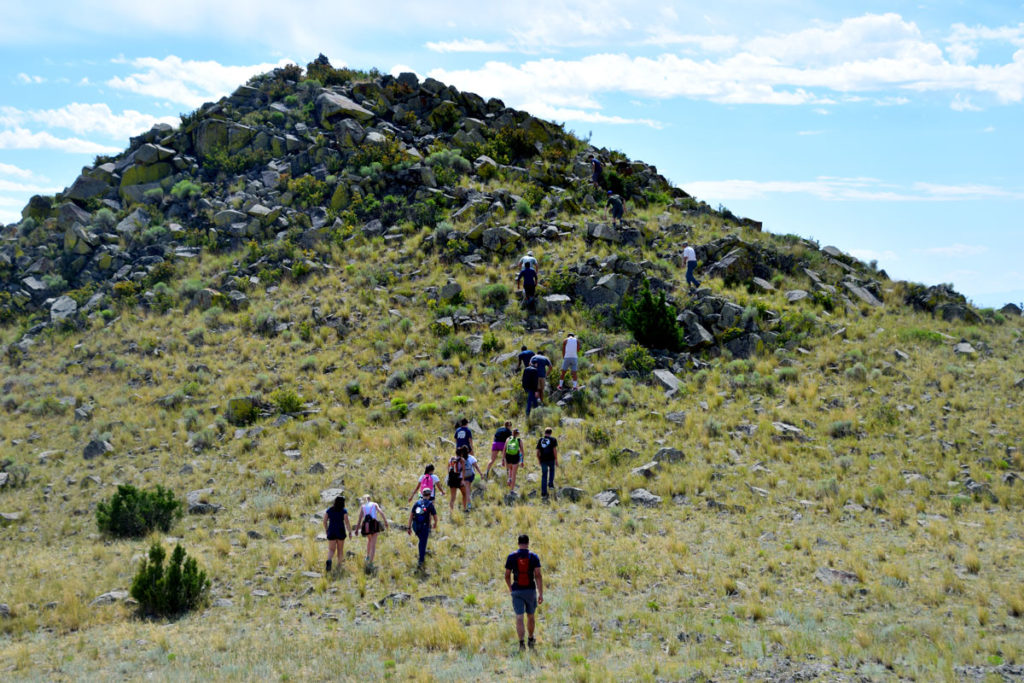 Webb School students hiking up to the "Looking-Out" site associated with the buffalo jump. A eagle catchment area is immediately below the highest point of the "Looking-Out" site.